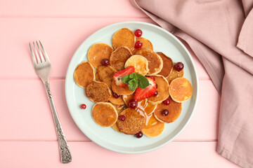 Cereal pancakes with berries served on pink wooden table, flat lay