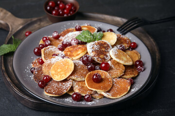 Cereal pancakes with cranberries served on black table