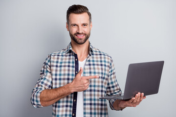 Photo portrait of businessman keeping laptop pointing finger advising isolated on grey color background