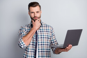 Portrait of attractive skilled content bearded guy holding in hand using laptop it isolated over gray pastel color background