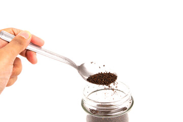 A hand hold a spoon with a blended and dried tea leaf isolated on white background