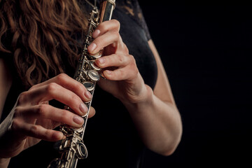 Close-up of the hands of a woman playing the flute. Musical concept.