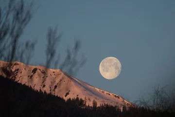 at sunrise on the mountains and the moon goes down
