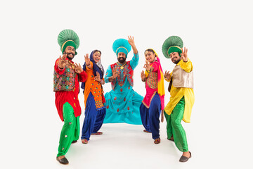 A Troupe of Punjabi Folk Dancers demonstrating a Dance step with hand Gestures.	
