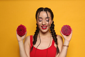 Young woman with fresh pitahaya on yellow background. Exotic fruit