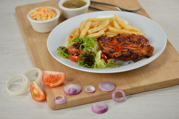 delicious plate of western food chicken chop with fries and salad