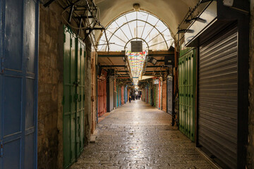 Naklejka na ściany i meble Closed shops on Daniel Street Arab market on a rainy day near the Yafo Gate in the old city of Jerusalem, in Israel