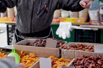 Man sells dried fruits in farm market. Close up