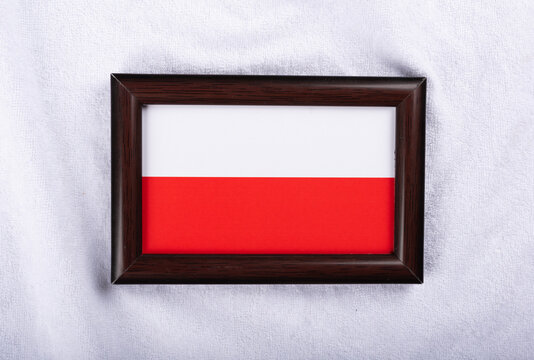Poland flag in a realistic frame on white cloth background flat lay photo