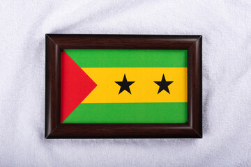 Sao Tome and Principe flag in a realistic frame on white cloth background flat lay photo.