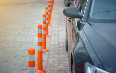Boundary posts in the parking lot and pedestrian zone. Lot of striped orange reflictive traffic...