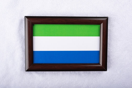  Sierra Leone flag in a realistic frame on white cloth background flat lay photo