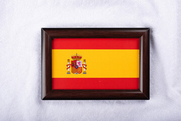 Spain flag in a realistic frame on white cloth background flat lay photo