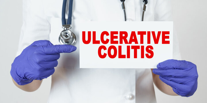 The Doctor Points His Finger At A Sign That Says - ULCERATIVE COLITIS