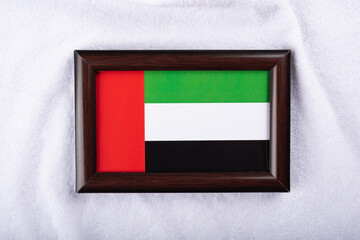 United Arab emirates flag in a realistic frame on white cloth background flat lay photo.
