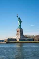 Statue of Liberty, an iconic neoclassical copper sculpture representing Libertas, the Roman goddess of liberty, holding up a torch and occupying a large pedestal on Liberty island, New York City, USA