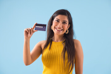 A young woman showing her credit card .	