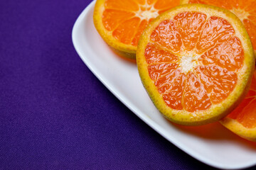 Fototapeta na wymiar Orange slices on white plate
