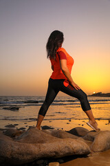 Woman  sports on the shore during sunset.