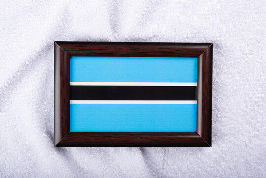 Botswana flag in a realistic frame on white cloth background flat lay photo