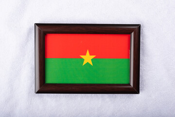 Burkina faso flag in a realistic frame on white cloth background flat lay photo