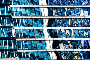 View of a modern glass skyscraper reflecting the blue sky blue . High quality photo