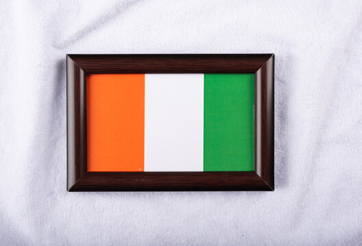 Cote d'Ivoire flag in a realistic frame on white cloth background flat lay photo