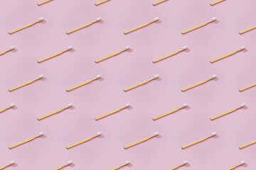 Pattern with wooden tooth brushes on pink background.