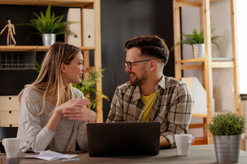 Couple is smiling in the living room while using technology. Close up.