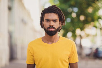 Photo portrait of young man serious confident standing on street in summer wearing casual clothes