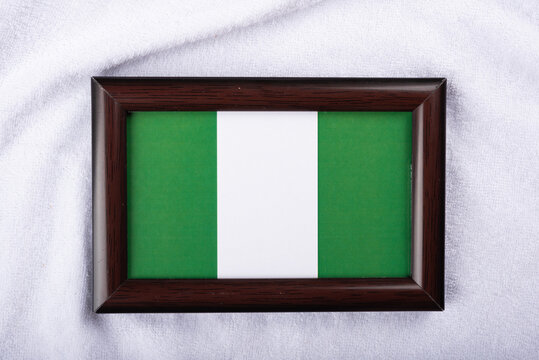 Nigeria flag in a realistic frame on white cloth background flat lay photo.