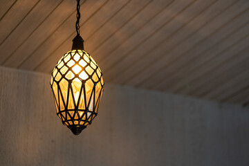 A luxury electric lamp in crystal shape or water droplet design during glowing in warming light for relaxation. Interior decorative object photo. Selective focus.