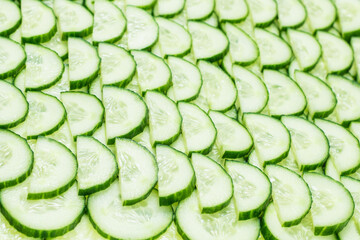 Fresh green slices of cucumber as background.