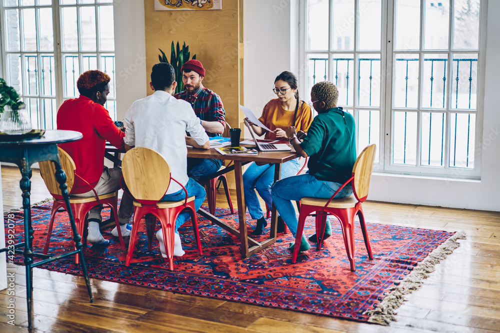 Aufkleber multicultural group of colleagues dressed in casual wear discussing working plan and strategy while 