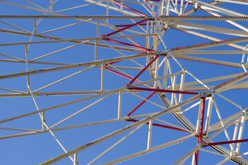 Naklejka premium Ferris wheel constraction on the blue sky background. City pattern and lines.