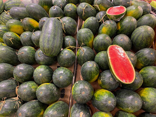 Pile of oval shaped red watermelon for sale at fruit market 