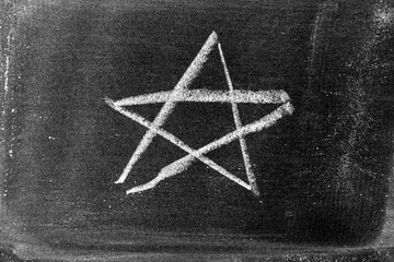 White color chalk hand drawing as star shape on blackboard  or chalkboard background