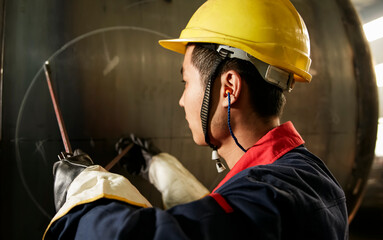 Asian workers are using compasses to mark steel
