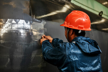 Workers in Asia are using plastic sealant to seal steel for protection