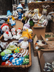 Knitted mittens and doll toys on stalls at Christmas market in Riga of Latvia winter. Street Xmas and holiday fair in European city or town. Advent Decoration with Crafts Items on Bazaar