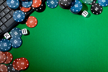 Online gaming platform, casino and gambling business. Dice and multi-colored game pieces on a laptop keyboard on a green background