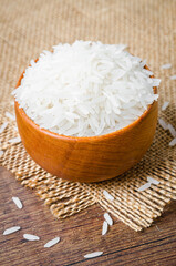 Organic Thai Jasmine rice grain in wooden bowl.