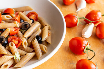 Penne pasta with tomatoes and black olives
