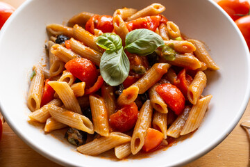 Penne pasta with tomatoes and black olives