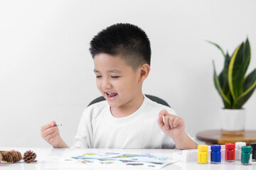 Happy little Asian kid at the table draw with watercolor Learning and education of kid.