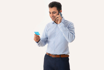 A CORPORATE MAN HOLDING A BUSINESS CARD IN HAND AND TALKING IN MOBILE	