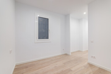 Empty white room with a window with a lattice. Modern apartment is after renovation