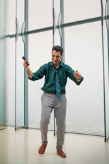 A CORPORATE EMPLOYEE HAPPILY DANCING WHILE LISTENING TO MUSIC	