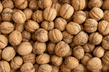 background of walnuts in shell, scattered pile of walnuts natural
