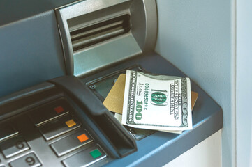 Money with a bank card is on the ATM.